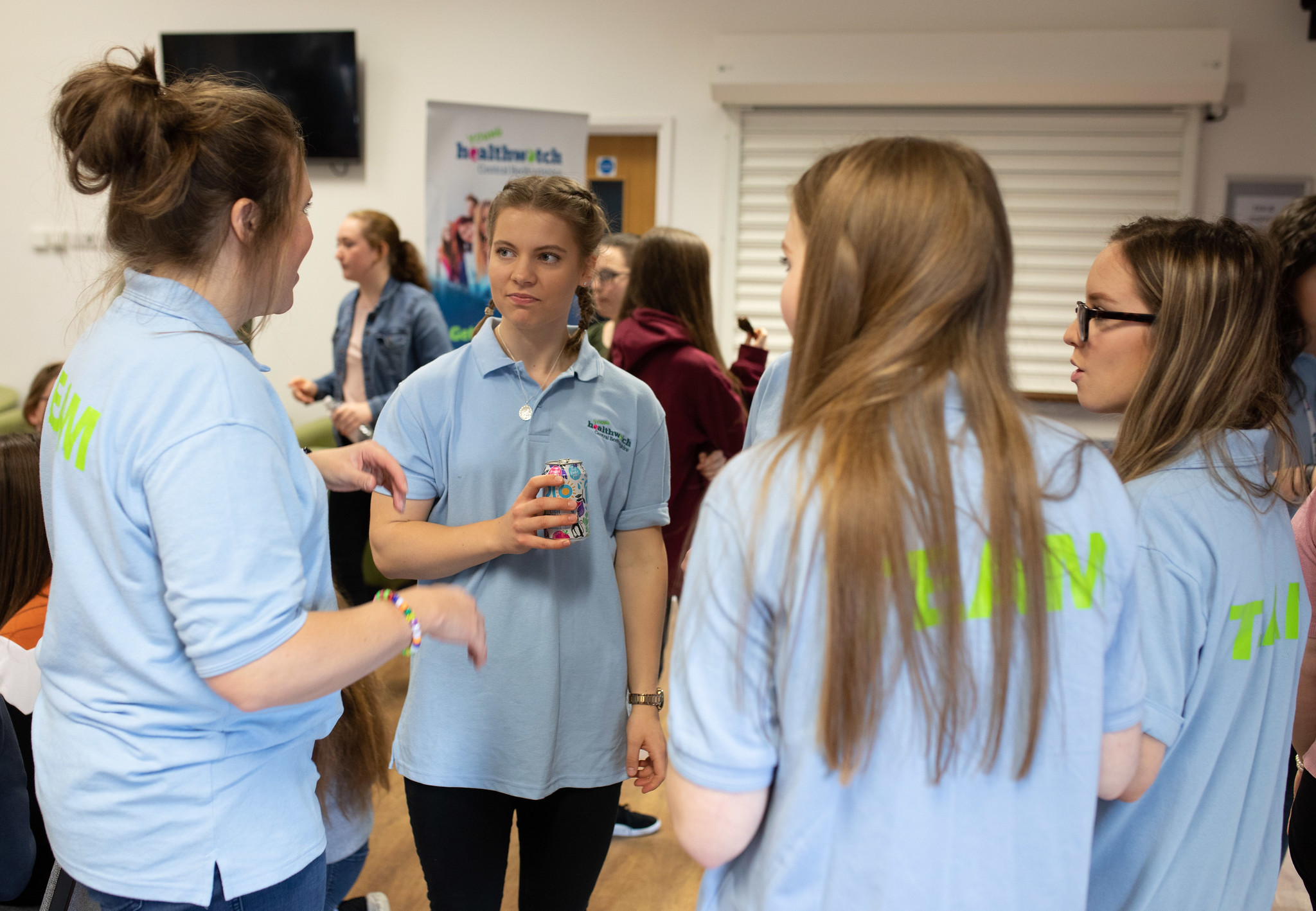 Group of young girls stood in a circle chatting 