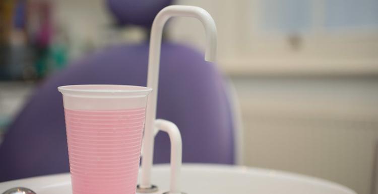 Mouthwash and tap in front of a dentist chair