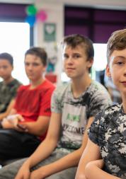 Young boys sitting in a row in a classroom